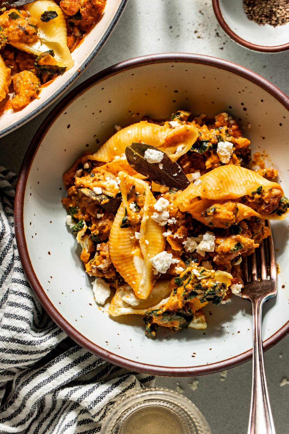 A white pasta bowl filled with pumpkin and feta stuffed shells.