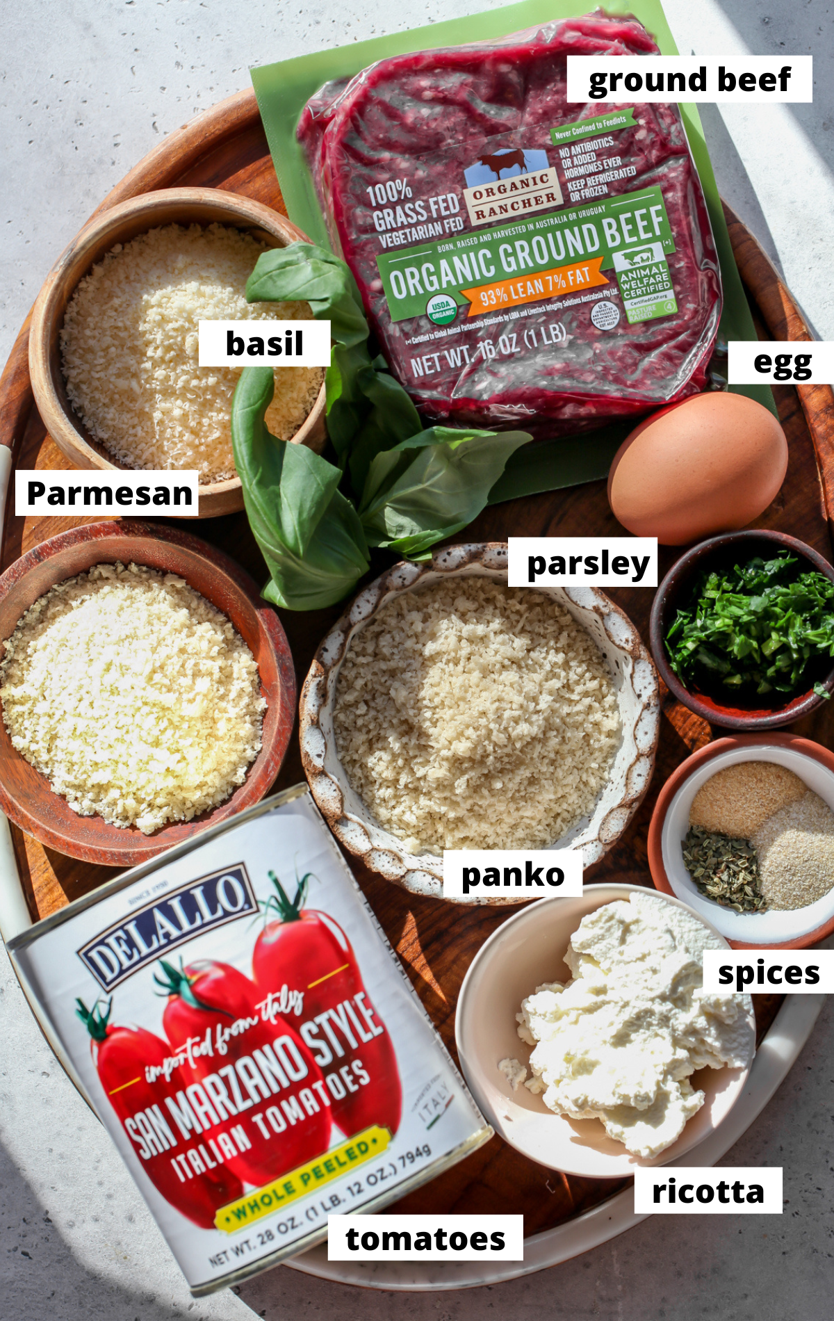 Recipe ingredients in separate bowls arranged on a wooden board with labels.
