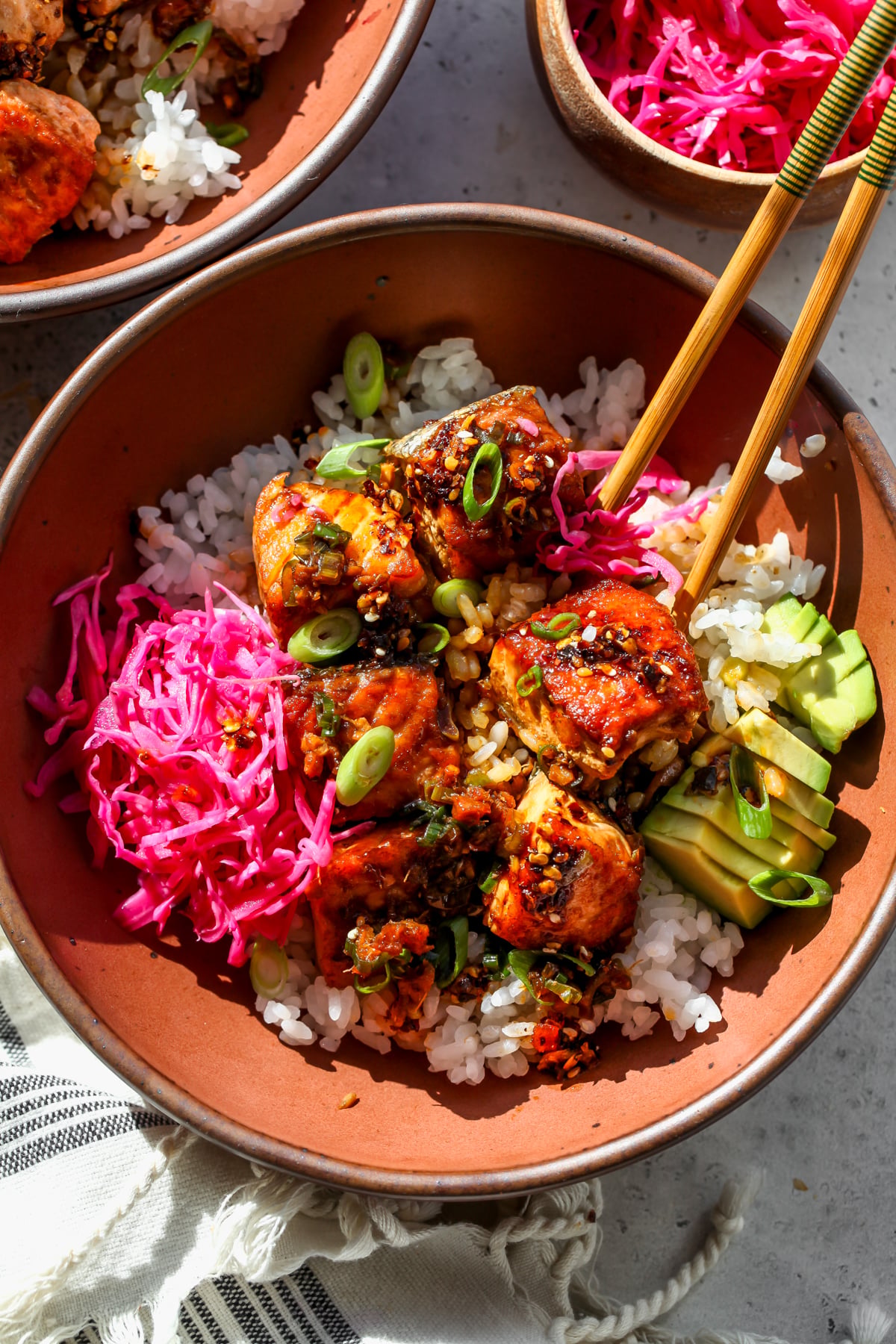 Ginger Scallion Salmon Bowl with pickled cabbage and avocado styled in a gold bowl.