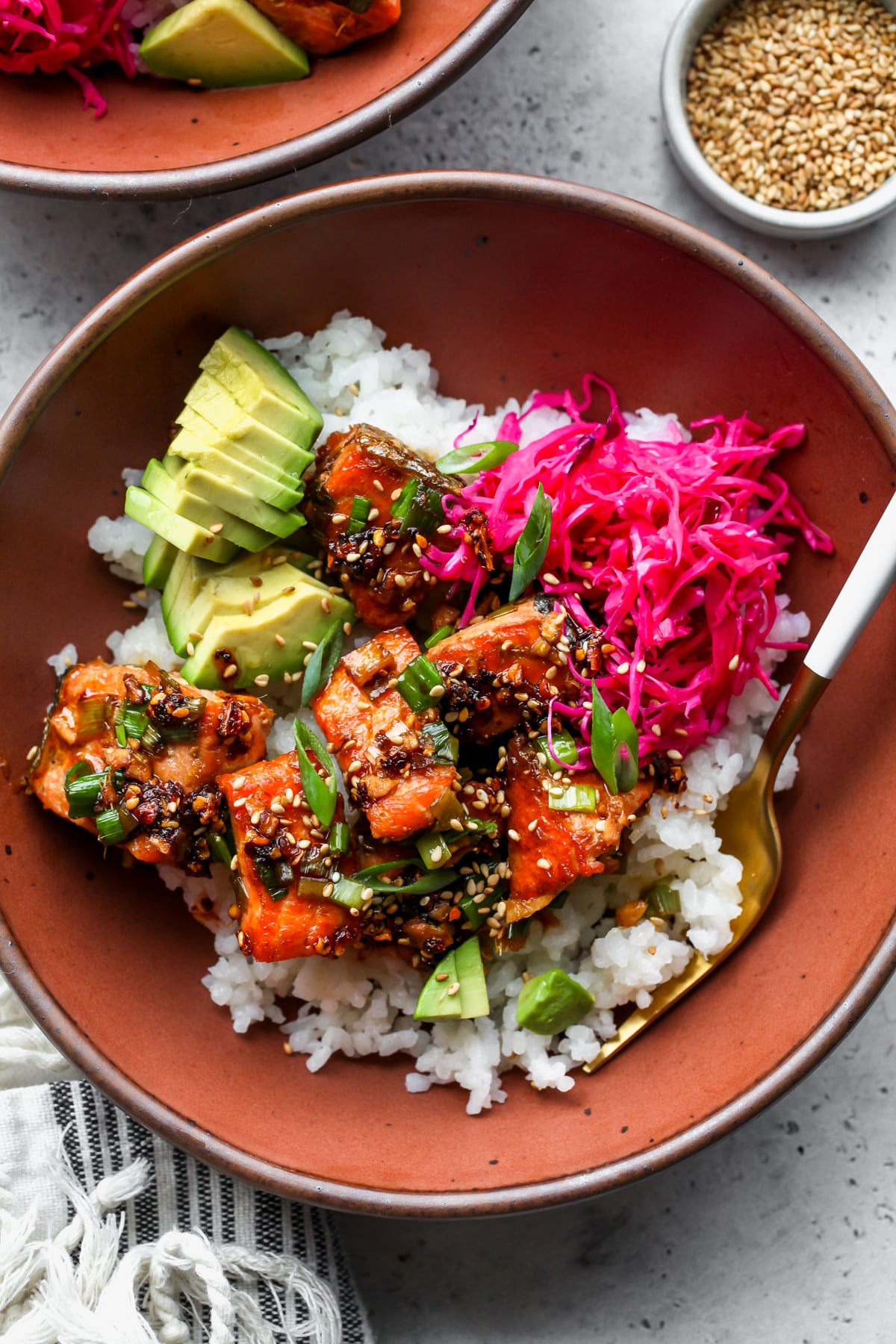 Salmon Bowls topped with ginger-scallion sauce in a clay-colored serving bowl.