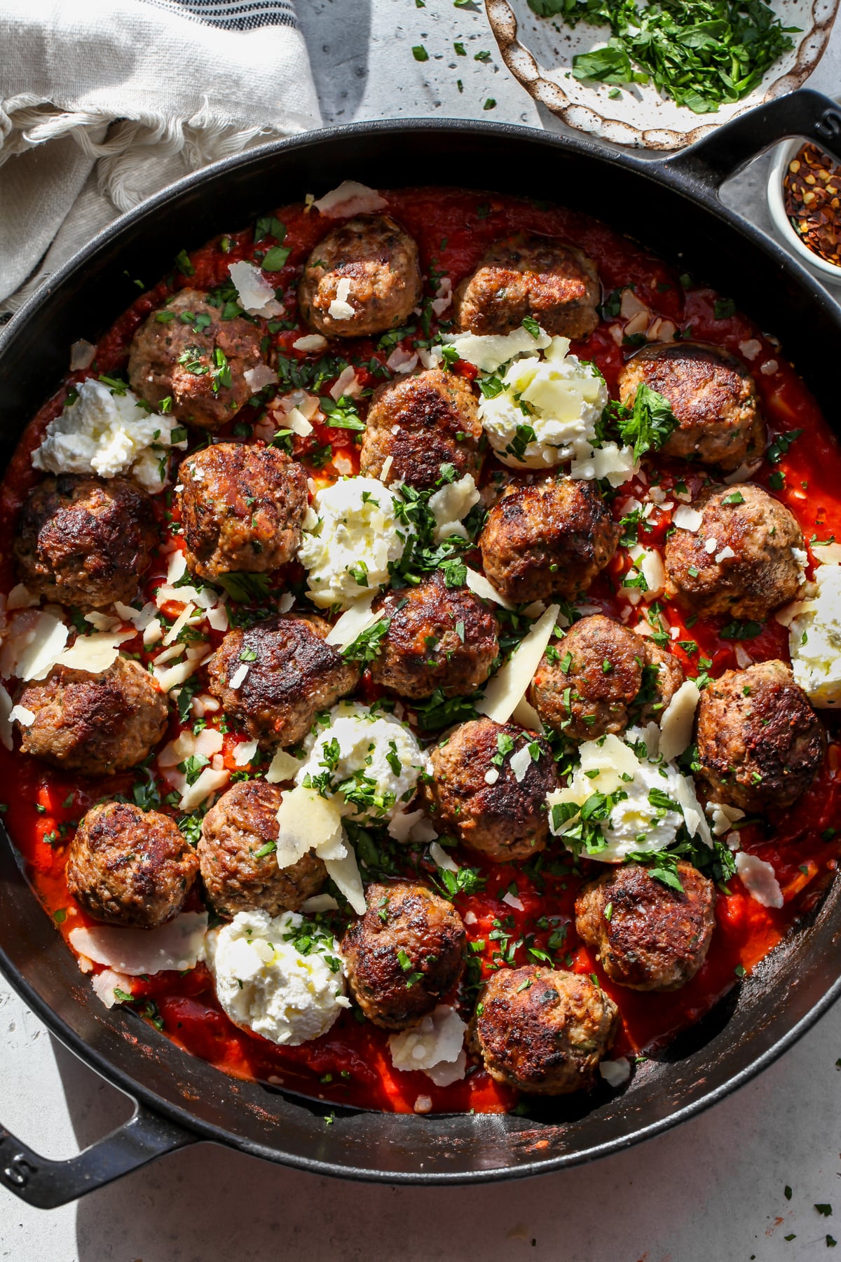 Skillet ricotta meatballs styled in a black cast iron skillet topped with parsley and Parmesan.