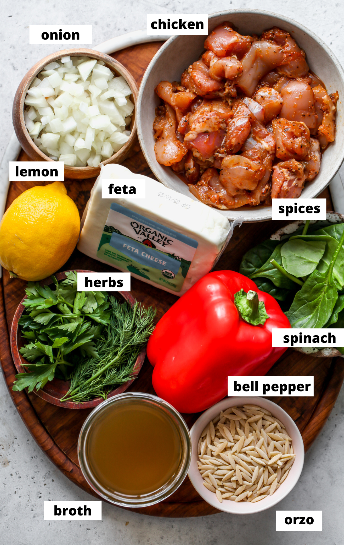 Recipe ingredients in separate bowls arranged on a wooden platter with labels.