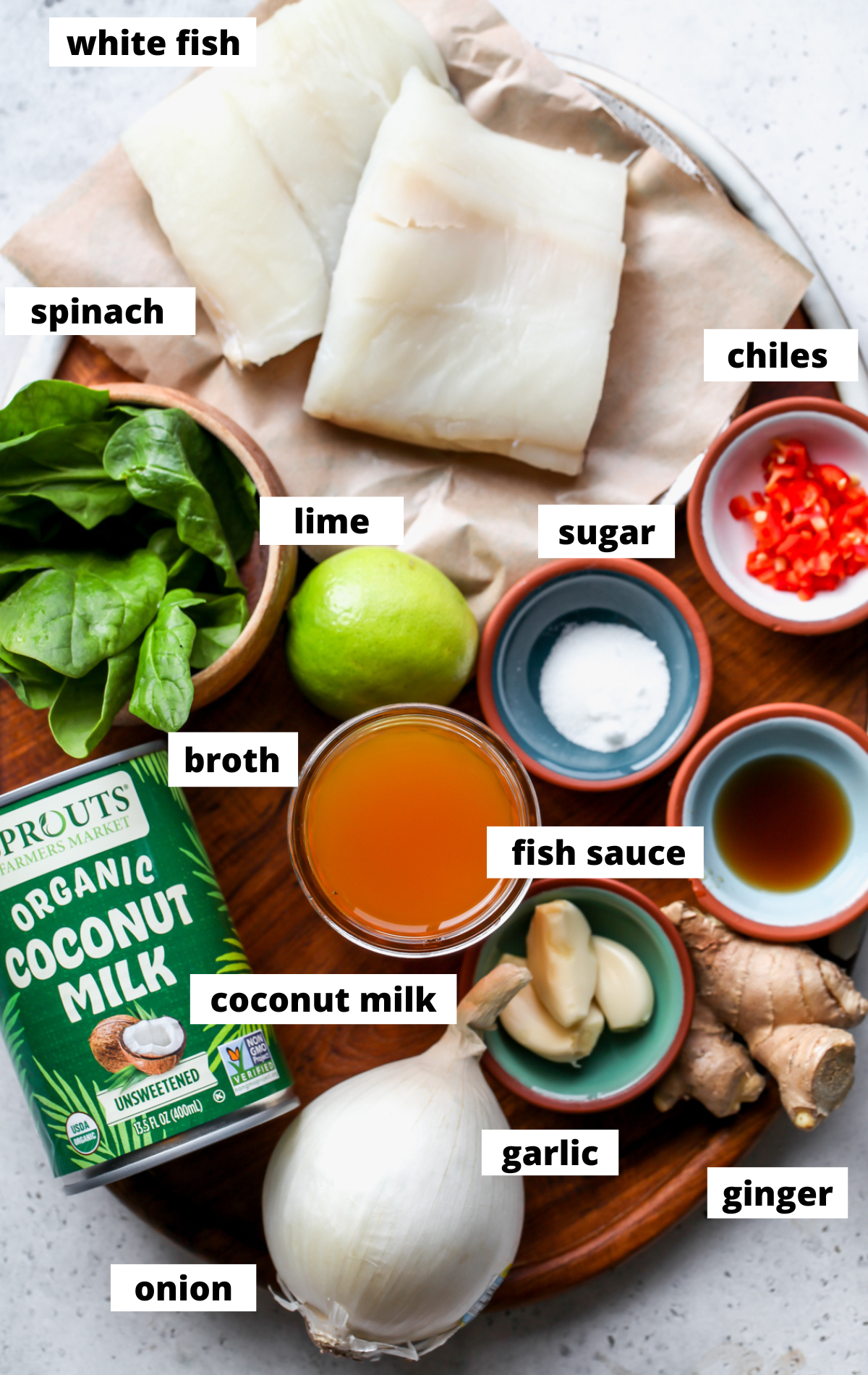 Recipe ingredients assembled in separate bowls on a wooden tray with labels.