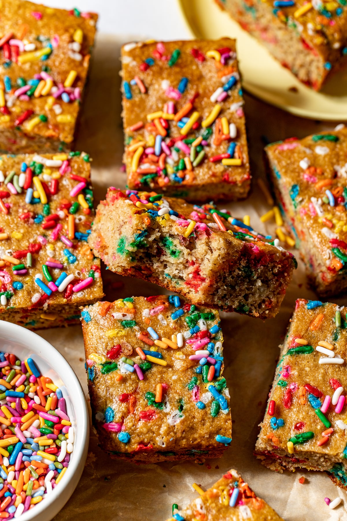 Funfetti banana bread bars sliced and arranged on a piece of parchment paper.