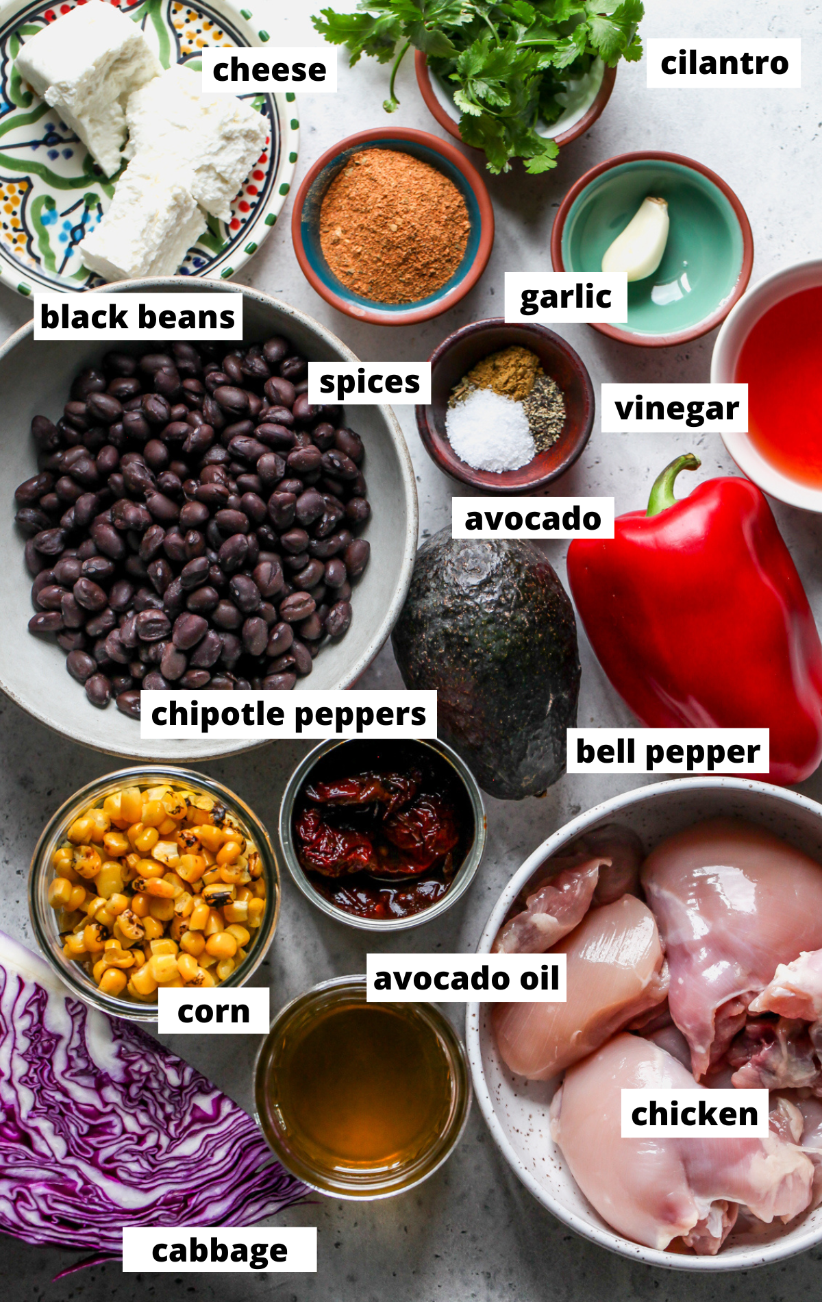 Recipe ingredients in separate bowls arranged on a gray surface with labels.