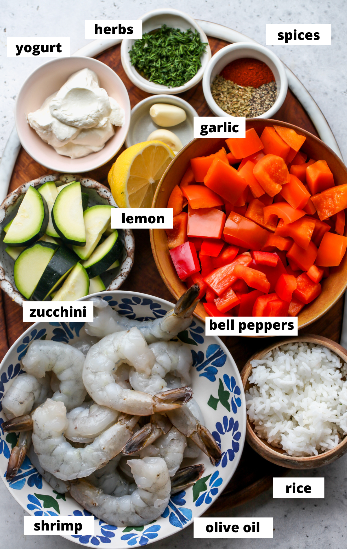 Recipe ingredients arranged in separate bowls on a wooden tray with labels.