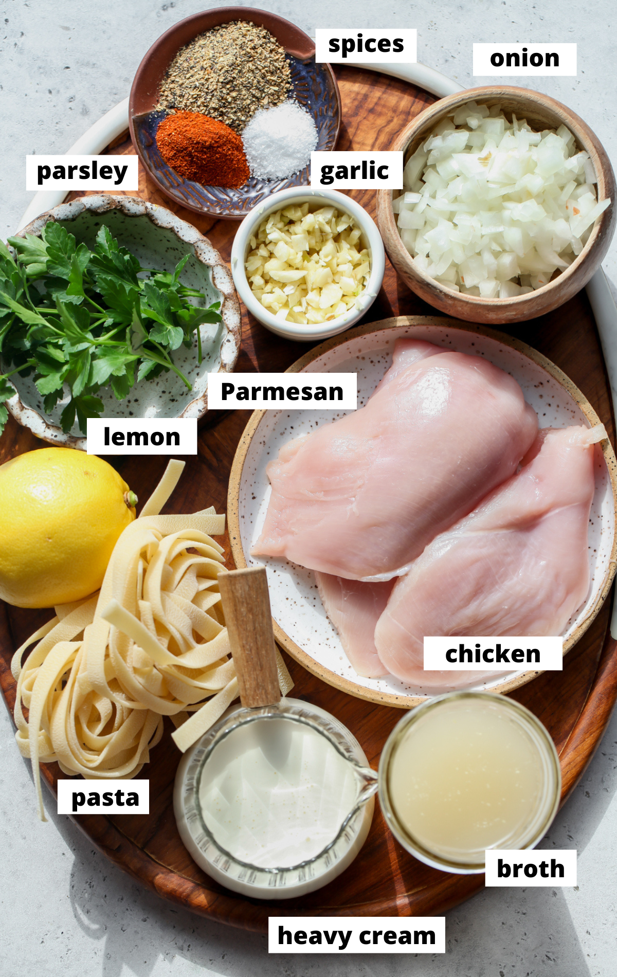 Recipe ingredients arranged on a wooden board with separate bowls with labels.