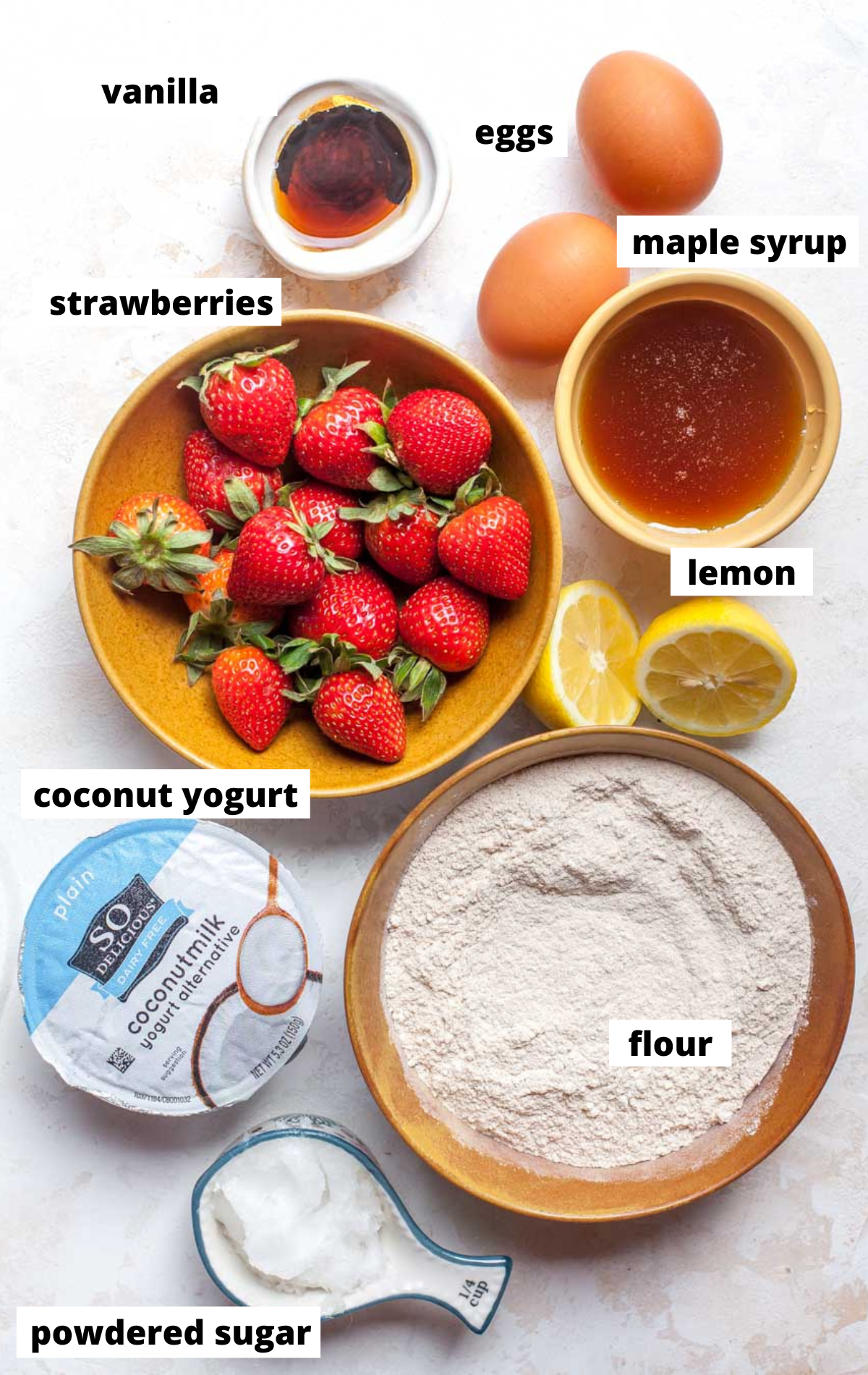 Recipe ingredients in separate bowls arranged on a white surface with labels.