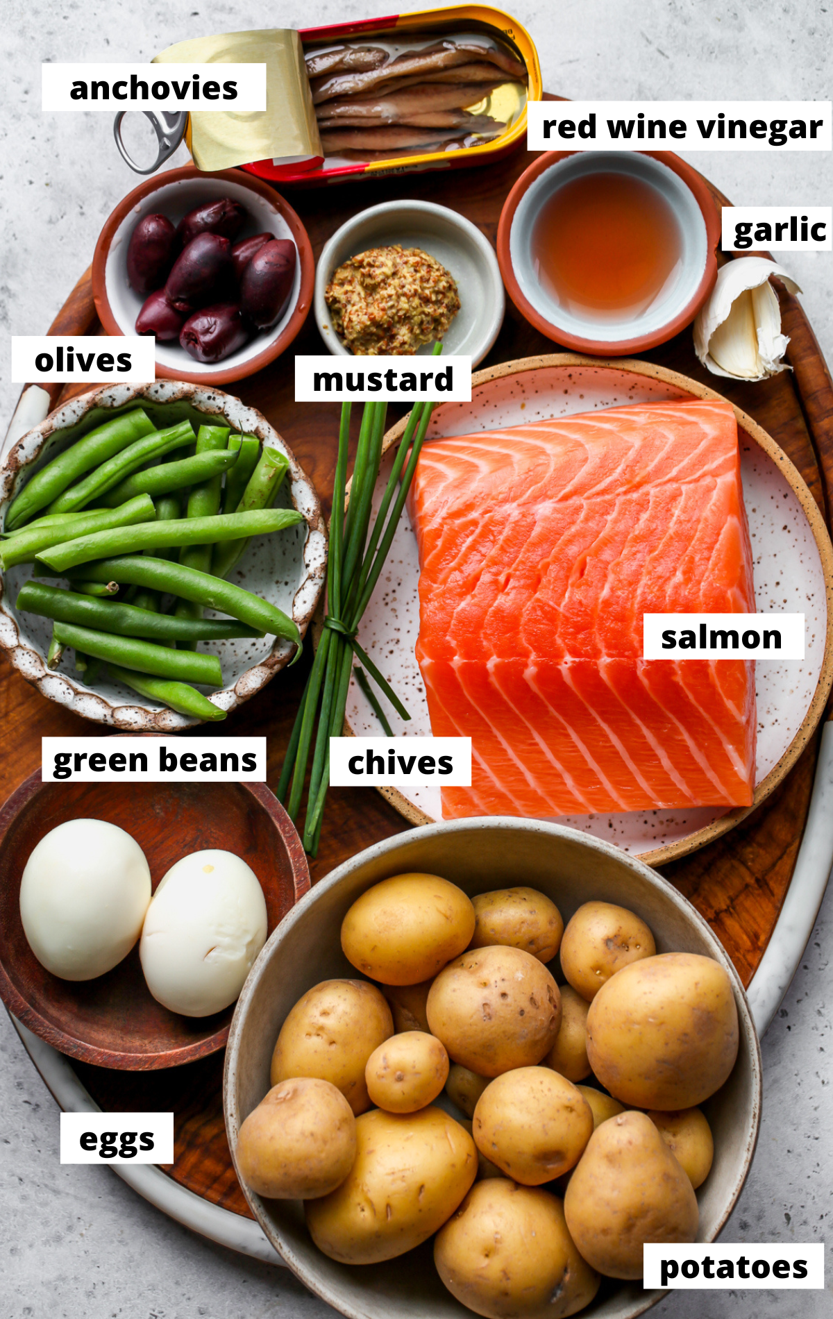 Recipe ingredients arranged on a wooden platter with labels.