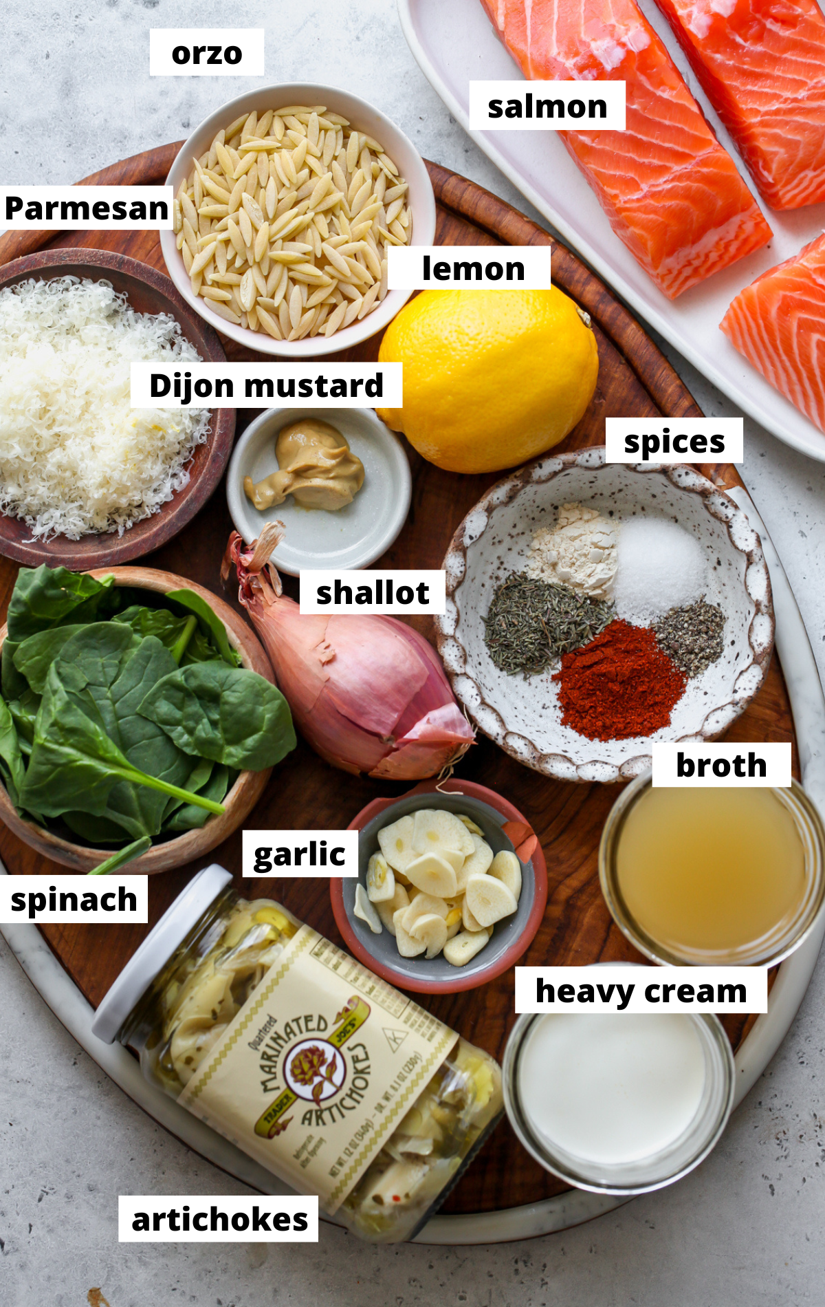 Recipe ingredients in separate bowls arranged on a wooden platter with labels.