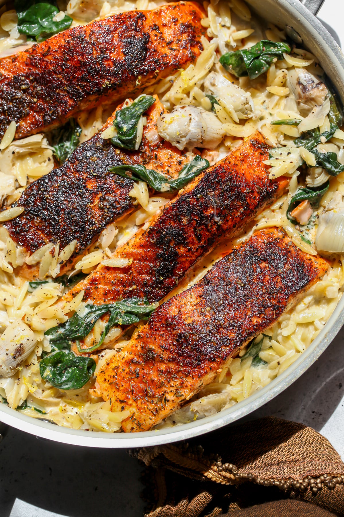 Spinach Artichoke Salmon styled in a sauté pan.