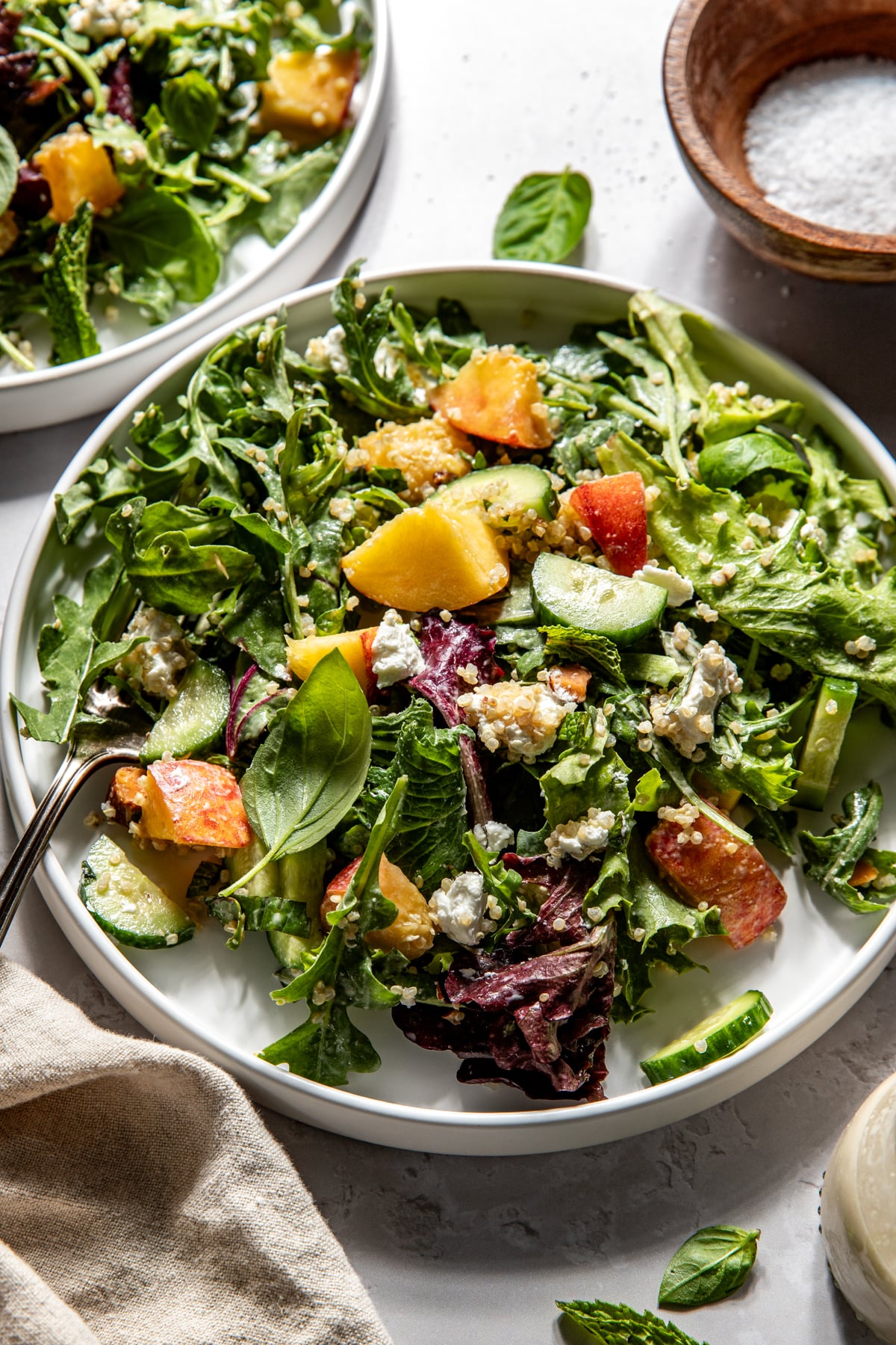 A single serving of peach goat cheese salad served on a small white plate.