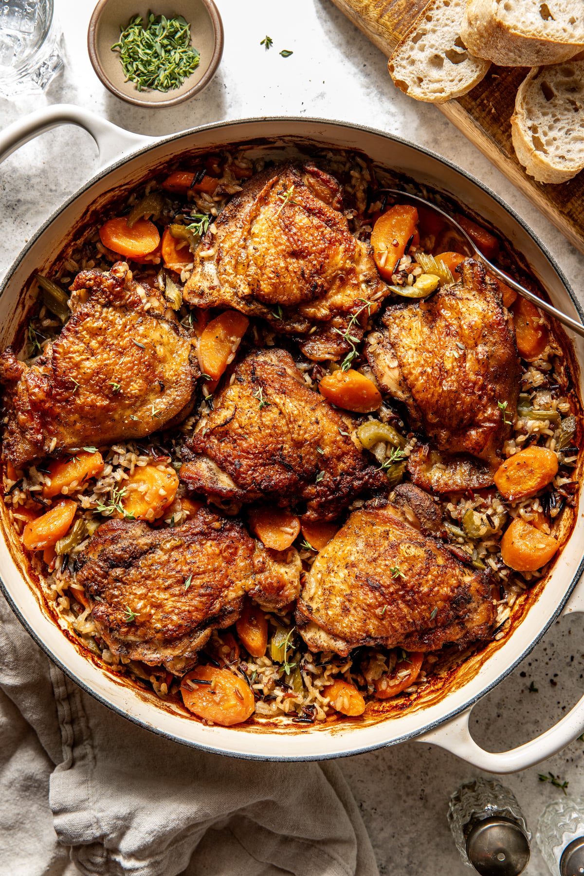 Chicken and wild rice styled in a pot after baking. Garnished with fresh thyme leaves.