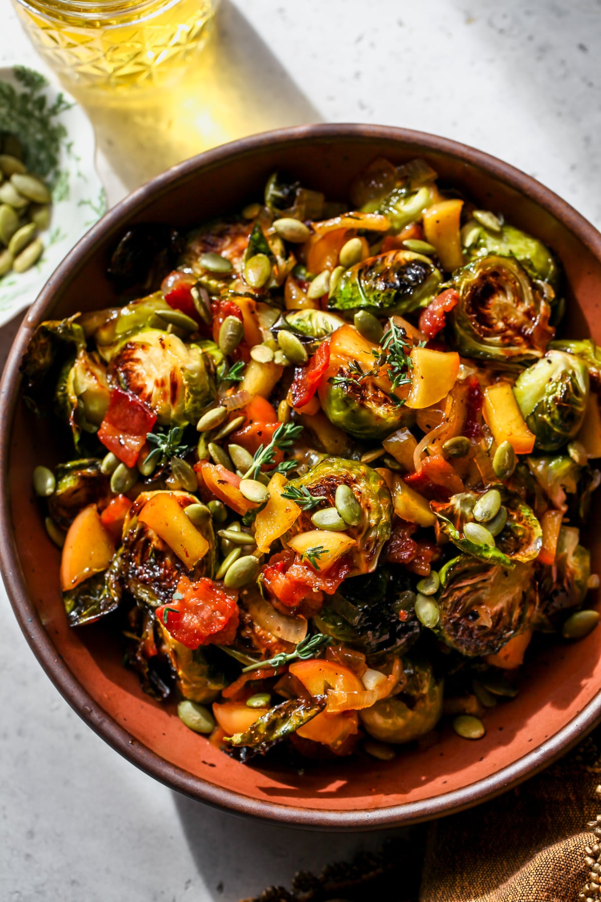 Cider-Glazed Brussels Sprouts styled in a maroon serving bowl.