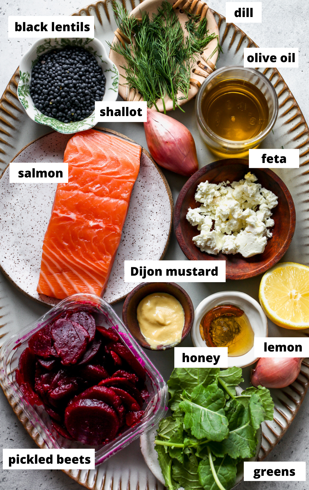 Recipe ingredients arranged in separate bowls on a scalloped serving tray with labels.