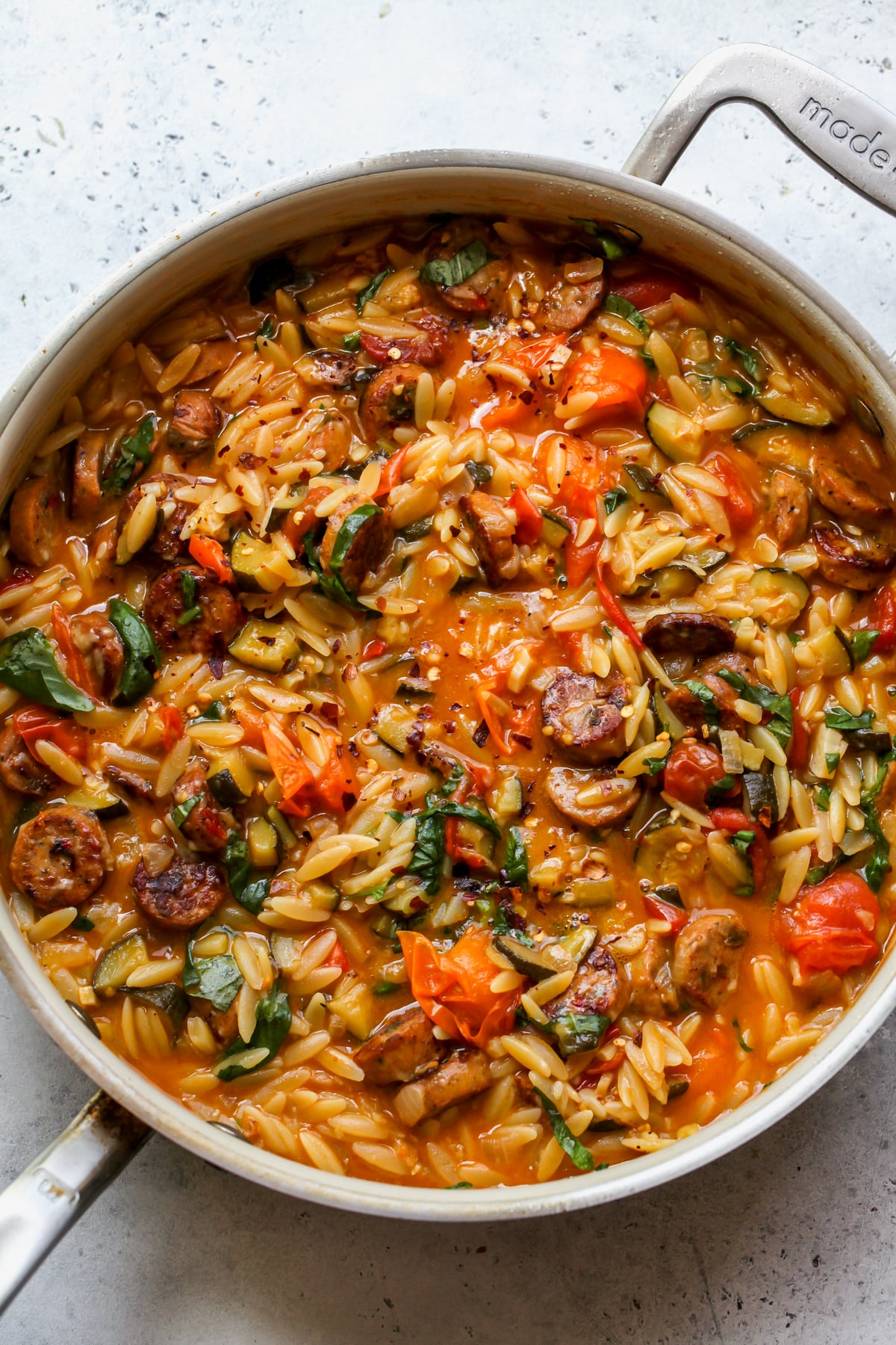 Chicken sausage, orzo, and veggies after being boiled in a sauté pan.