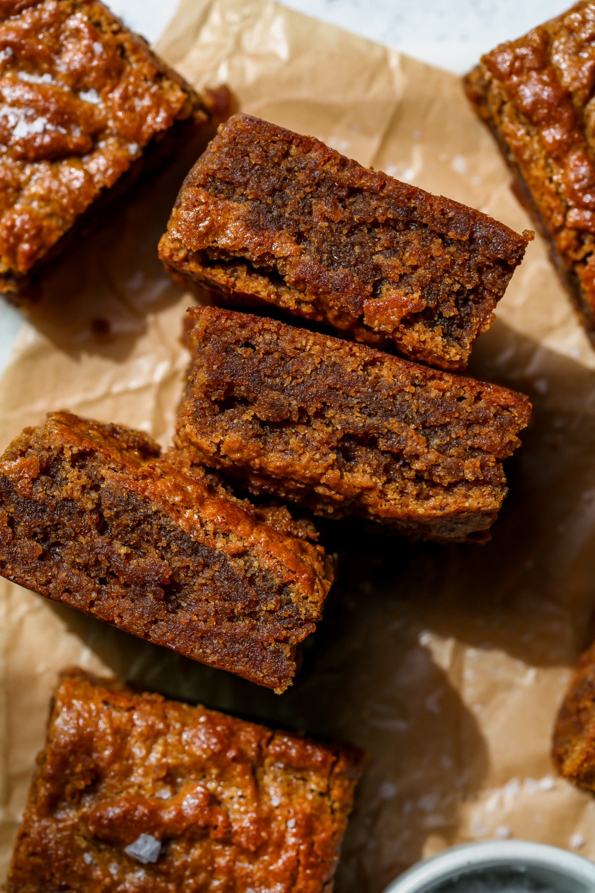 Brown Butter Pumpkin Tahini Bars arranged on a piece of parchment paper on a white surface.